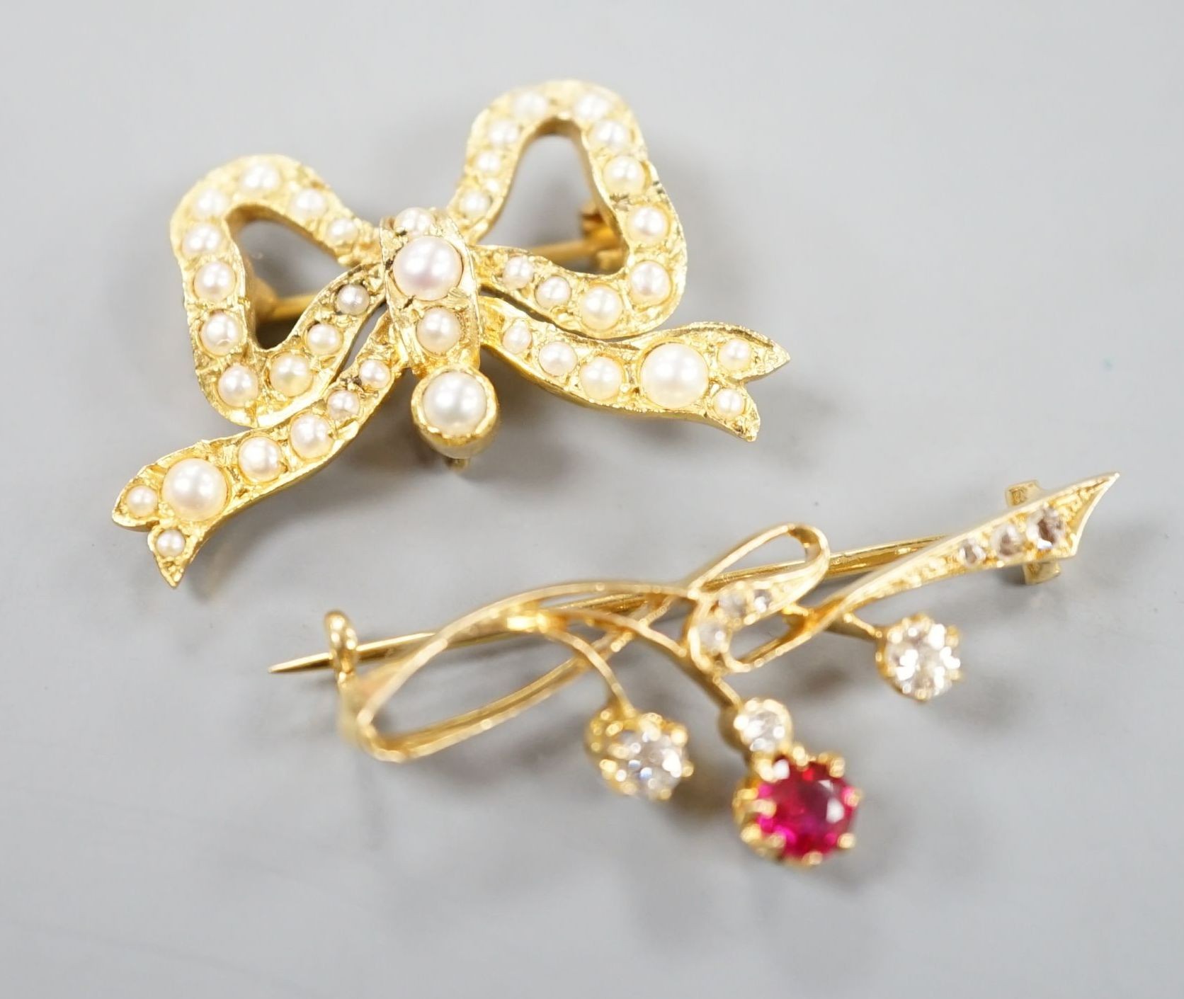 A yellow metal, ruby? and diamond set brooch, 36mm and a modern 9ct gold and split pearl set ribbon bow brooch, gross 8.5 grams.